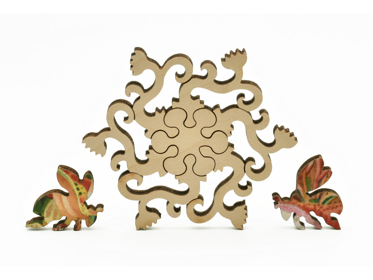 A closeup of pieces in the shape of a flowering vine and bees.