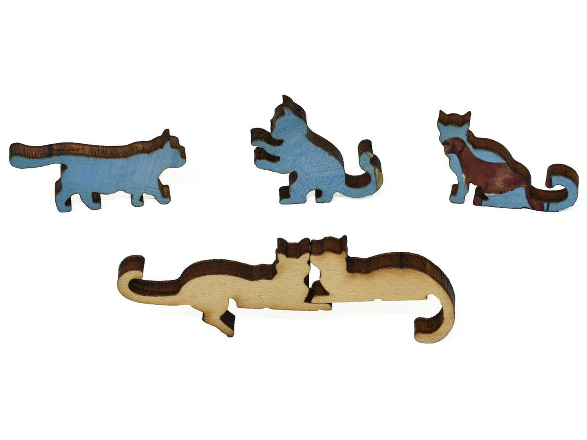 A closeup of pieces showing two cats cuddling and three kittens.