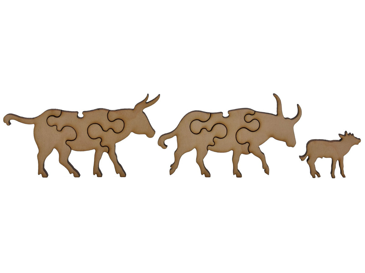 A closeup of pieces shaped like two cattle and a calf.