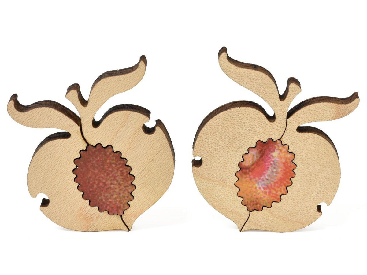 A closeup of pieces that show two peaches with their colorful pits from the puzzle, Palisade Peach Basket.