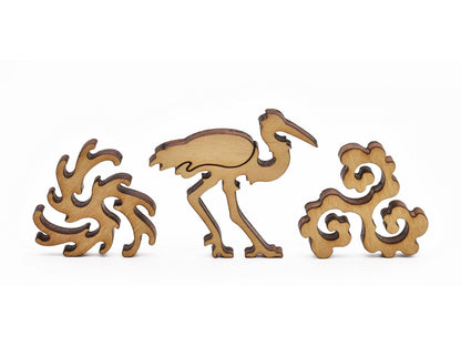 A closeup of pieces in the shape of a crane and water swirls.