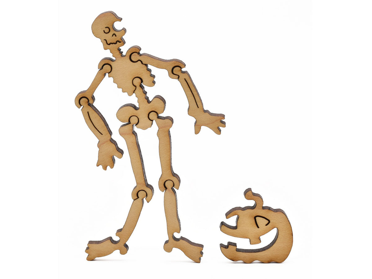 A closeup pf pieces in the shape of a skeleton and a jack o' lantern.