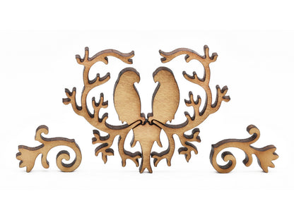 A closeup of pieces shaped like two lovebirds surrounded by a heart of branches.