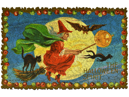 The front of the puzzle, Halloween Spirit, which shows a witch flying on a broomstick with two black cats.