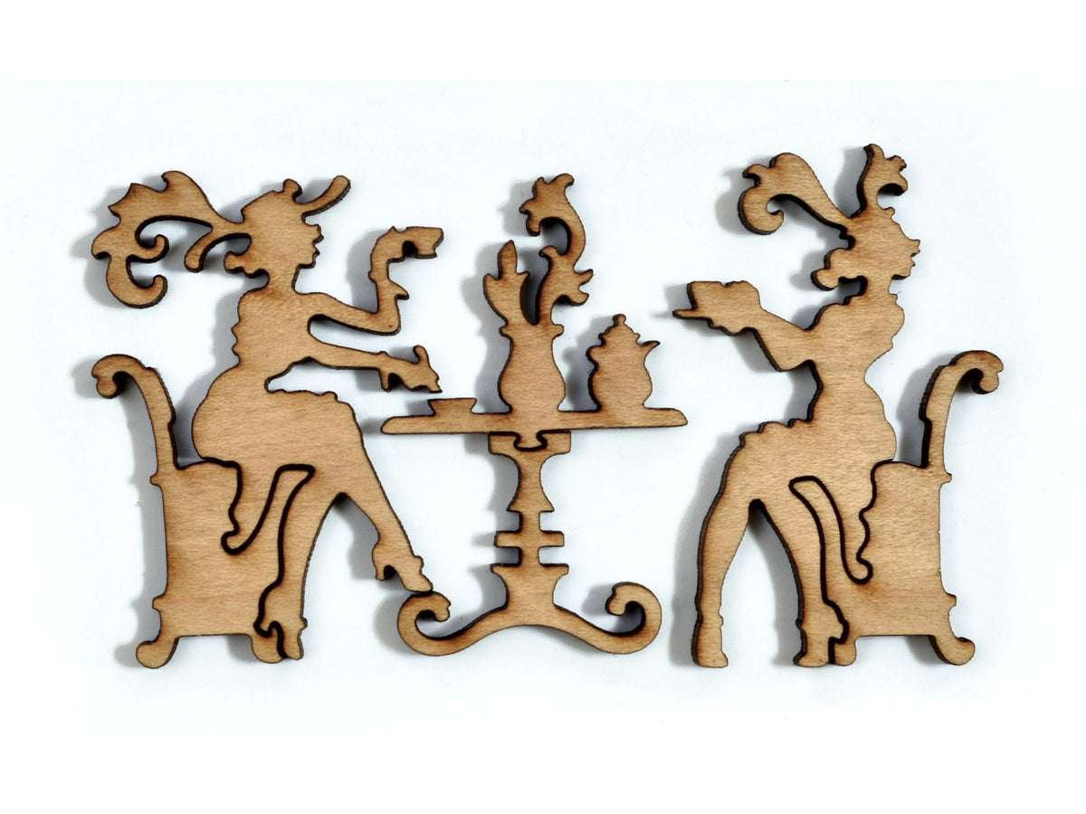 A closeup of pieces in the shape of a two people at a table having tea.