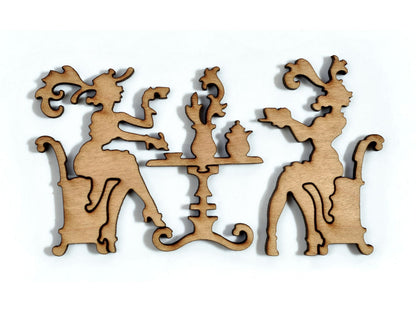 A closeup of pieces in the shape of a two people at a table having tea.